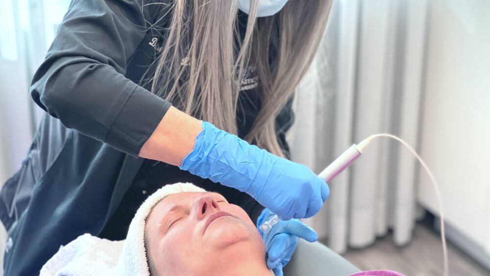 A woman receives microneedling treatment
